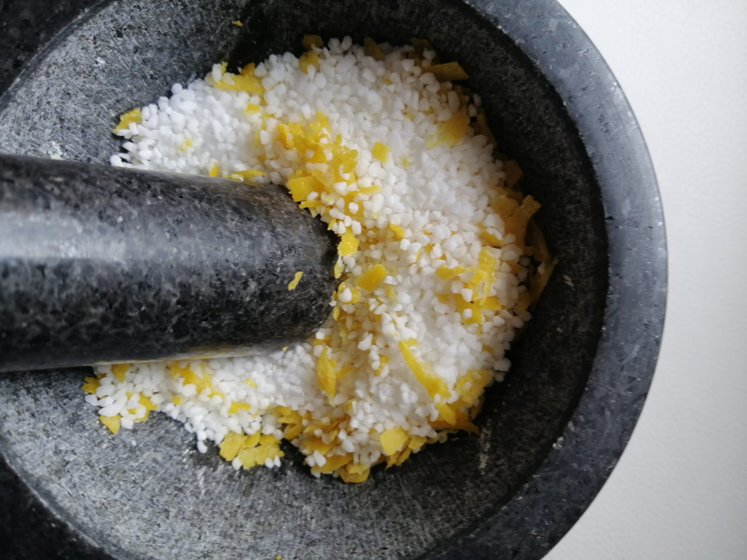 Salz und Zitronenabrieb in einem schwarzen Mörser. 